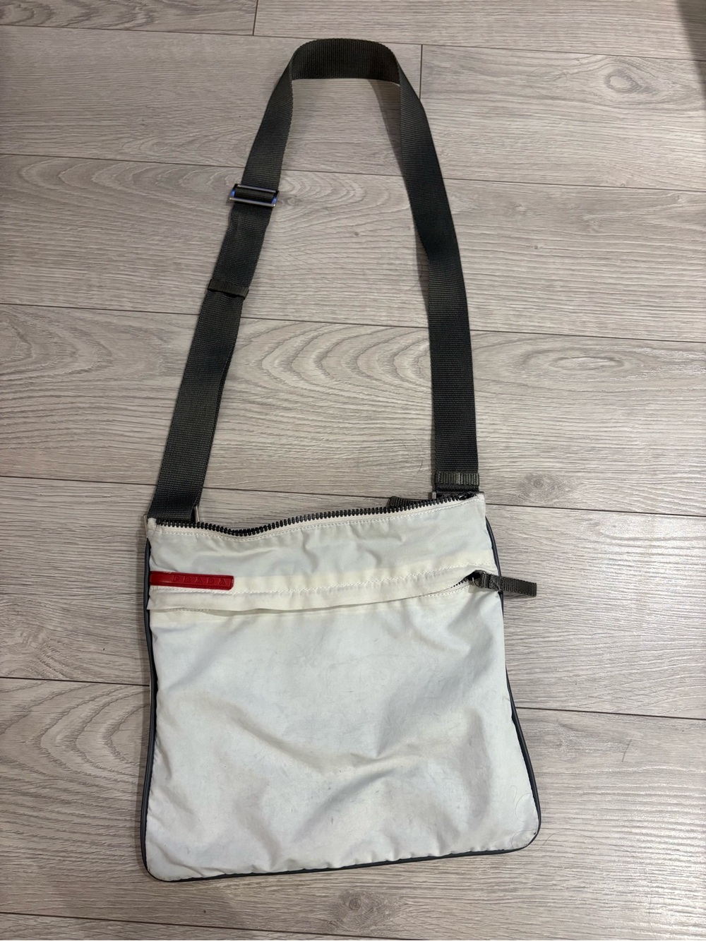 Prada White Crossbody Bag with charcoal grey Strap and trim.